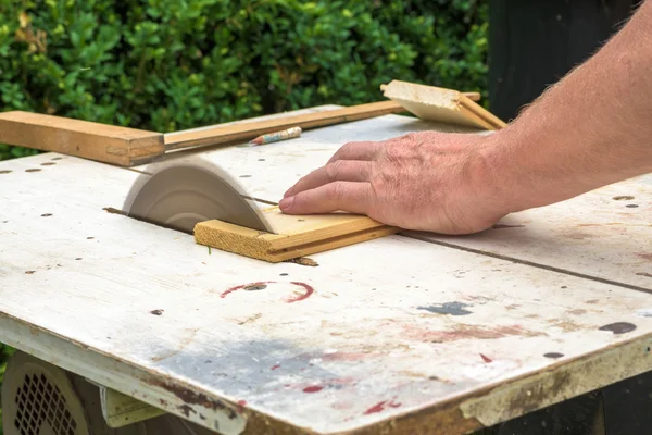 Carpintero trabajando con sierra eléctrica para cortar tableros de madera — Foto de Stock