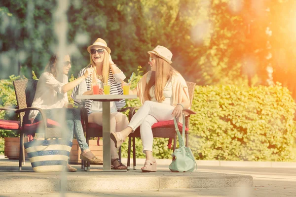 Tři atraktivní kamarádky těší koktejl v venkovní kavárně, přátelství koncepce — Stock fotografie