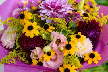 Yaz buketi. Güzel şeftali, sarı, mor, morumsu, fuşya ve bordo çiçeği düzenlemesi. Yaz çiçeklerinden yapılmış doğum günü ya da düğün buketi.