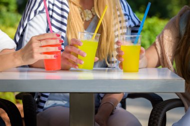 Açık bir kafede, dostluk kavramı kokteyller tatmak üç çekici kız