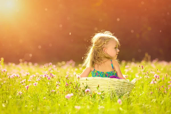 Чарівна маленька блондинка розважається, граючи на відкритому повітрі під час сонячного літа вдень — стокове фото