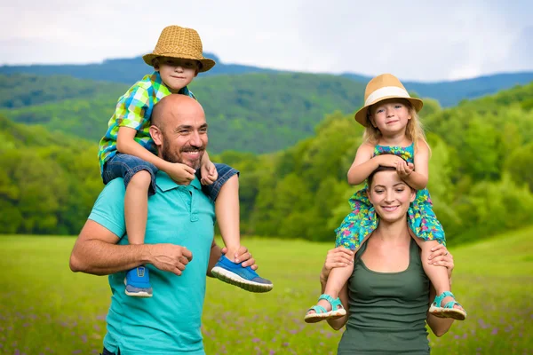 Ouders waardoor meeliften rit naar kinderen, gelukkig familie tijd concept — Stockfoto