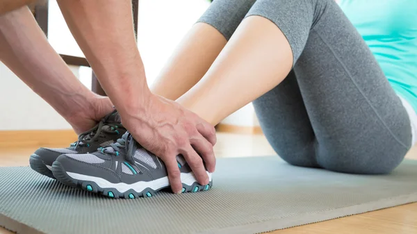 Personlig tränare att hjälpa ung attraktiv kvinna gör crunches i gymmet — Stockfoto