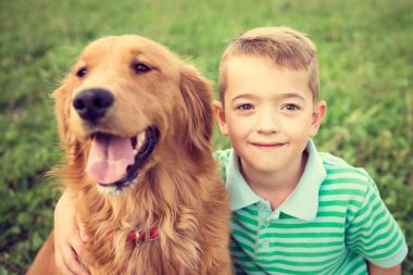 Sevimli küçük çocuk onun golden retriever evcil köpek sarılma