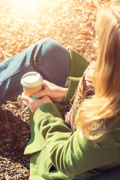 शरद ऋतु अवधारणा, अज्ञात महिला धूप के ठंडे पतन के दिन ले जाने वाले कॉफी कप का आनंद ले रही है — स्टॉक फ़ोटो, इमेज