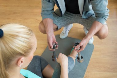 Halter egzersiz oturumu sırasında genç kadına teslim Personall eğitmen