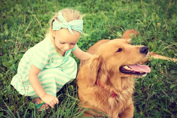 Gadis pirang kecil yang manis bermain dengan anjing peliharaannya yang lucu. — Stok Foto