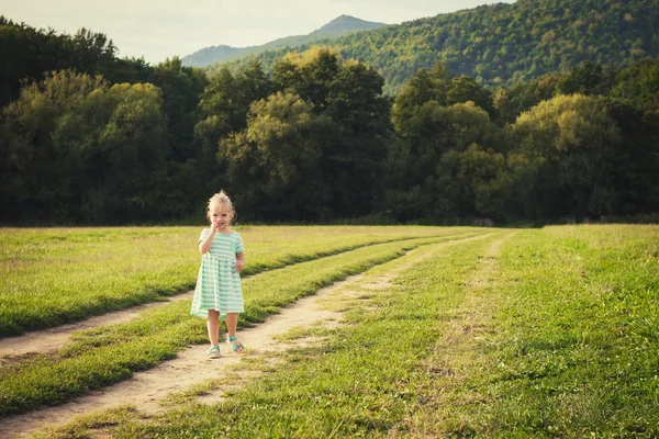 Adorable little girl on a sun covered meadow — Stock Photo, Image