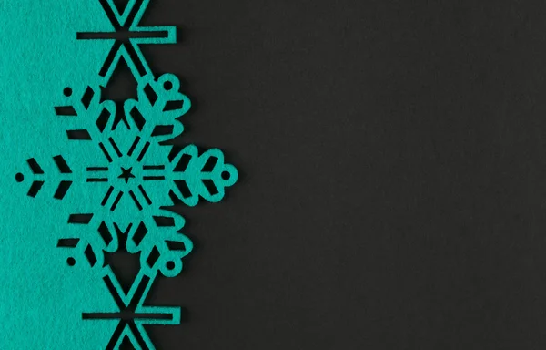 Diseño inusual fondo de Navidad con copos de nieve de color turquesa y espacio de copia sobre fondo gris oscuro —  Fotos de Stock