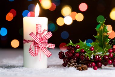 Yanan mum ile karda, kırmızı yay ile peri ışıkları, bokeh arka planda, neşeli Noel arka plan defocussed