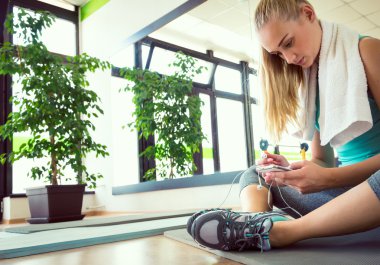 Akıllı telefon, jimnastik salonu iş sonra dinlenme çekici sarışın kadınla