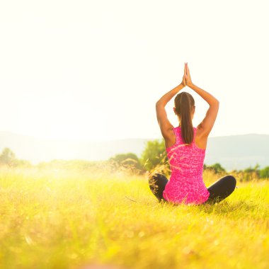 Pratik Yoga bir çayır mercek parlaması ile günbatımı, görüntü üzerinde genç atletik kadın