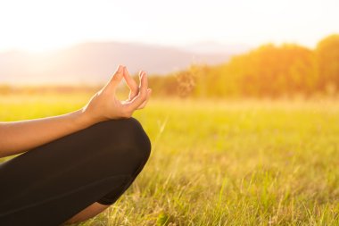 Pratik Yoga bir çayır mercek parlaması ile günbatımı, görüntü üzerinde genç atletik kadın