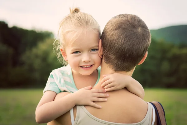 Adorável menina sorrindo e abraçando sua mãe — Fotografia de Stock