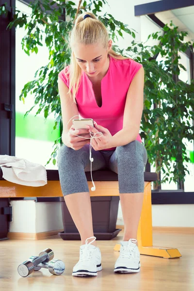 Attraktiv blond kvinna med smart telefon, vila efter gym verk — Stockfoto