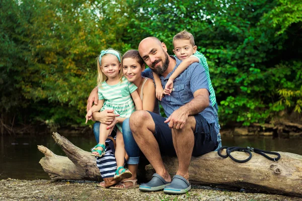 Hermosa familia joven con su perro mascota, golden retriever — Foto de Stock