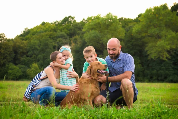 Güzel genç ailesi ile onların evde beslenen hayvan köpek, golden retriever — Stok fotoğraf