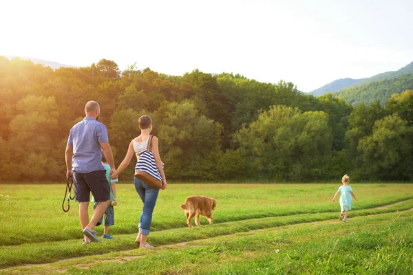 Vacker ung familj med deras sällskapsdjur hund, golden retriever — Stockfoto