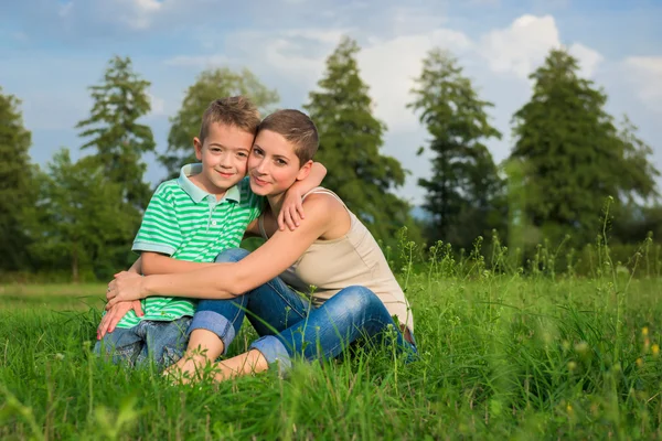 Madre e hijo posando para un retrato al aire libre, sonriendo —  Fotos de Stock