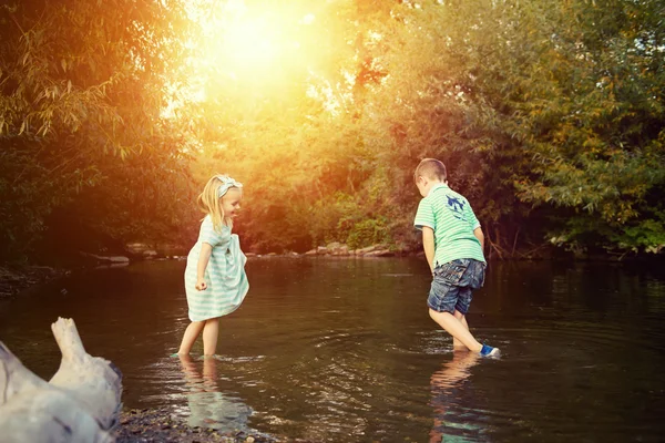 Hermanos jóvenes jugando en el río, concepto de exploración —  Fotos de Stock