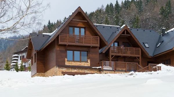 Krásný dřevěný domek pokryta sněhem, ski areál Donovaly, Slovensko — Stock fotografie