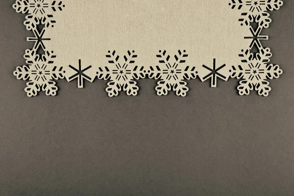 Diseño inusual fondo de Navidad con copos de nieve beige y espacio de copia sobre fondo marrón —  Fotos de Stock