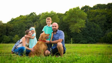 Güzel genç ailesi ile onların evde beslenen hayvan köpek, golden retriever