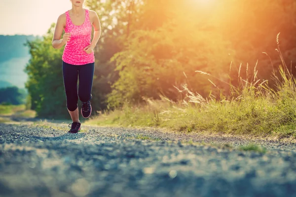 Aantrekkelijke jonge vrouwelijke joggen in platteland — Stockfoto