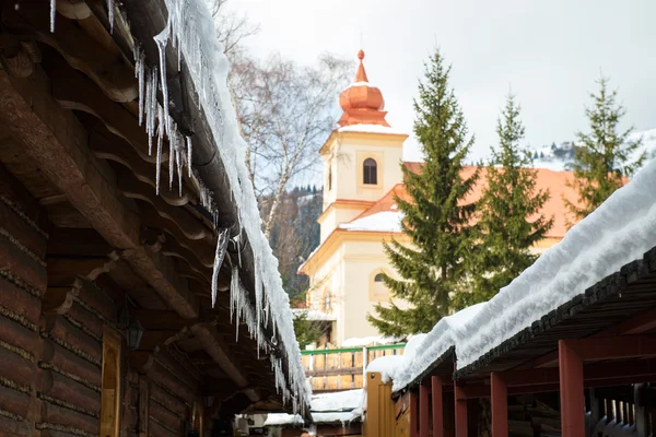 Ijspegels en sneeuw op een oude houten huisje, Donovaly, Slowakije — Stockfoto