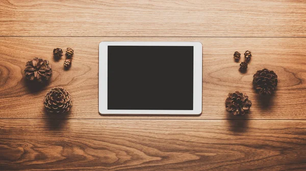 Magical christmas theme background, pine cones and digital tablet on wooden table — Stock Photo, Image