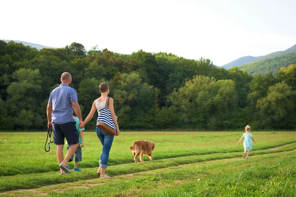 Hermosa familia joven con su perro mascota, golden retriever — Foto de Stock