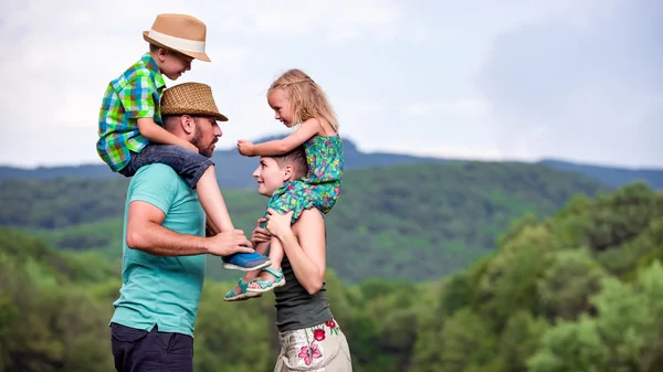 Родители катаются на спине с детьми, счастливая концепция семейного времени — стоковое фото