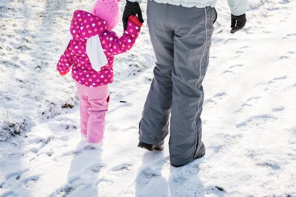 母亲和女儿走在一起抱着双手放在一个下雪的冬日 — 图库照片