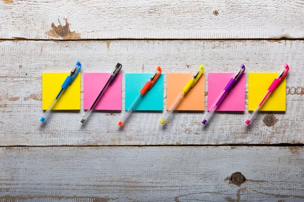 Retro white wooden table with empty colorful sticky notes and different gel pens — Stock Photo, Image