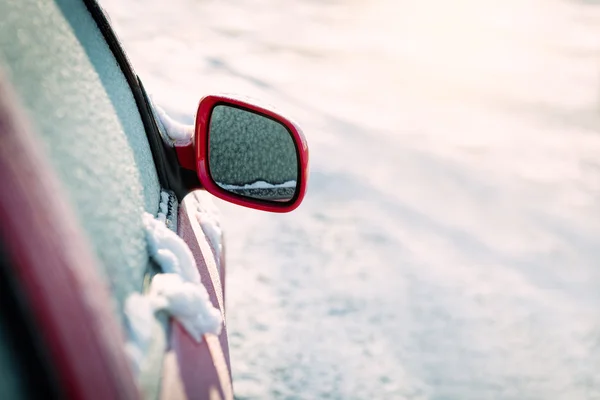 Congelado coche rojo estacionado fuera, con foco en el espejo retrovisor, problemas de transporte de invierno — Foto de Stock