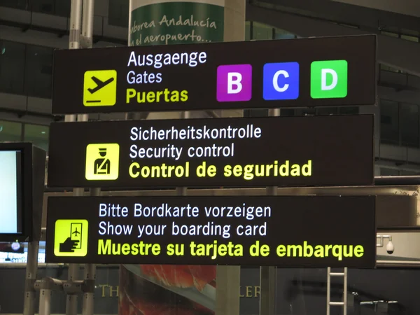 Уведомление аэропорта на трех языках — стоковое фото
