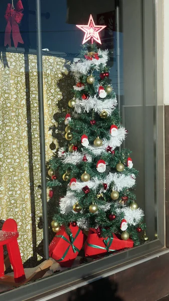 Decorated Christmas tree in village shop window