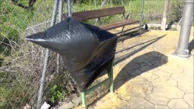 Güçlü rüzgarda uçuşan boş siyah plastik bir tombala çantası. Endülüs köyünün eteklerinde esen sert rüzgarla içi boş siyah plastik çanta ters döndü.