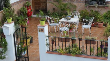 Endülüs köyünde masa, sandalye ve saksı bitkileri olan teras.