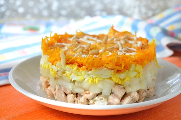 Salada em camadas com salmão, ovos, cebolas em conserva, cenouras Fotografia De Stock