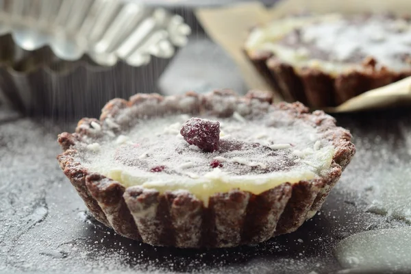 Tartes de chocolate com um recheio de ganache, creme e cerejas secas Imagem De Stock