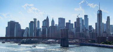 Manhattan Köprüsü 'nden Manhattan ve Brooklyn Köprüsü' nün aşağısında yazın mavi gökyüzü var.