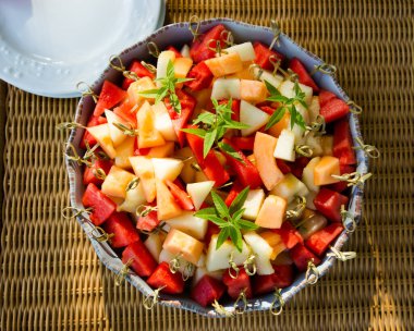 Büyük bir tabak taze meyve, kavun, karpuz, bambu çubukları..