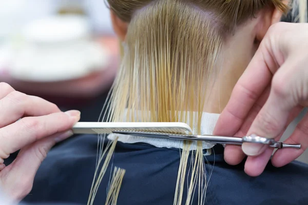 Парикмахер стрижется для блондинки-клиентки — стоковое фото