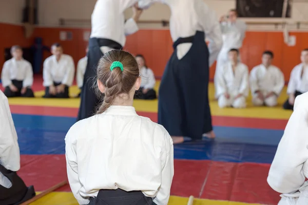 Dziewczyna w hakama siedzi na tatami na treningu sztuk walki — Zdjęcie stockowe