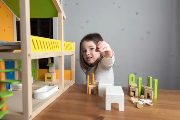 A little girl playing with dollhouse — Stock Photo, Image