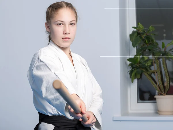 Una chica en hakama negro de pie en pose de lucha con palo jo de madera —  Fotos de Stock