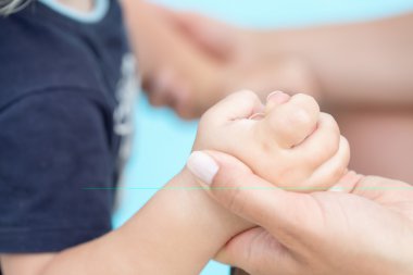 Toddler bebek tutan onun anneler parmak, seçici odak