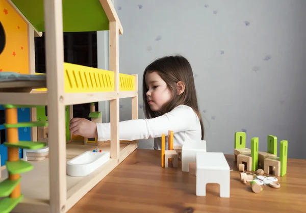 Dollhouse ile oynayan küçük bir kız