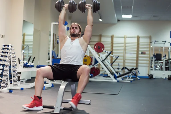 Starker Mann, Bodybuilder beim Training mit Kurzhanteln im Fitnessstudio — Stockfoto